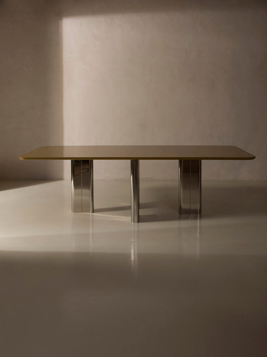 Mesa de comedor lacada en color ámbar con pata cromada