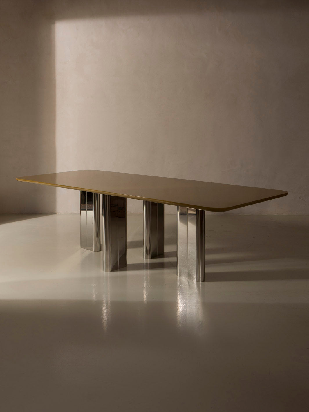 Mesa de comedor lacada en color ámbar con pata cromada