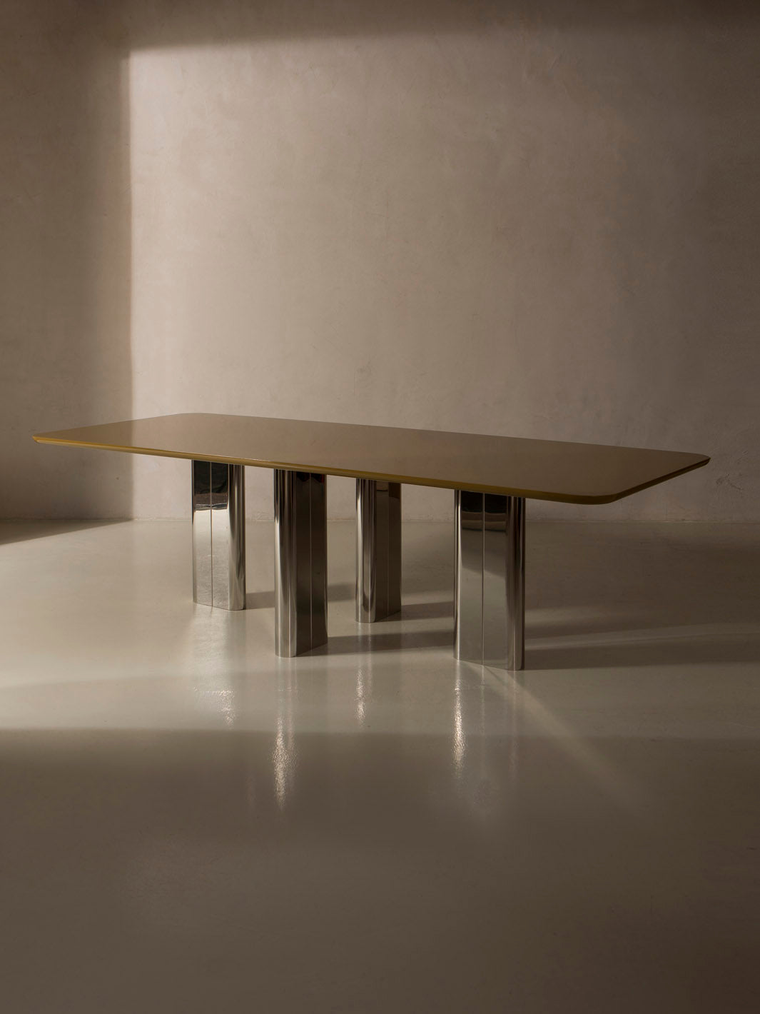 Mesa de comedor lacada en color ámbar con pata cromada