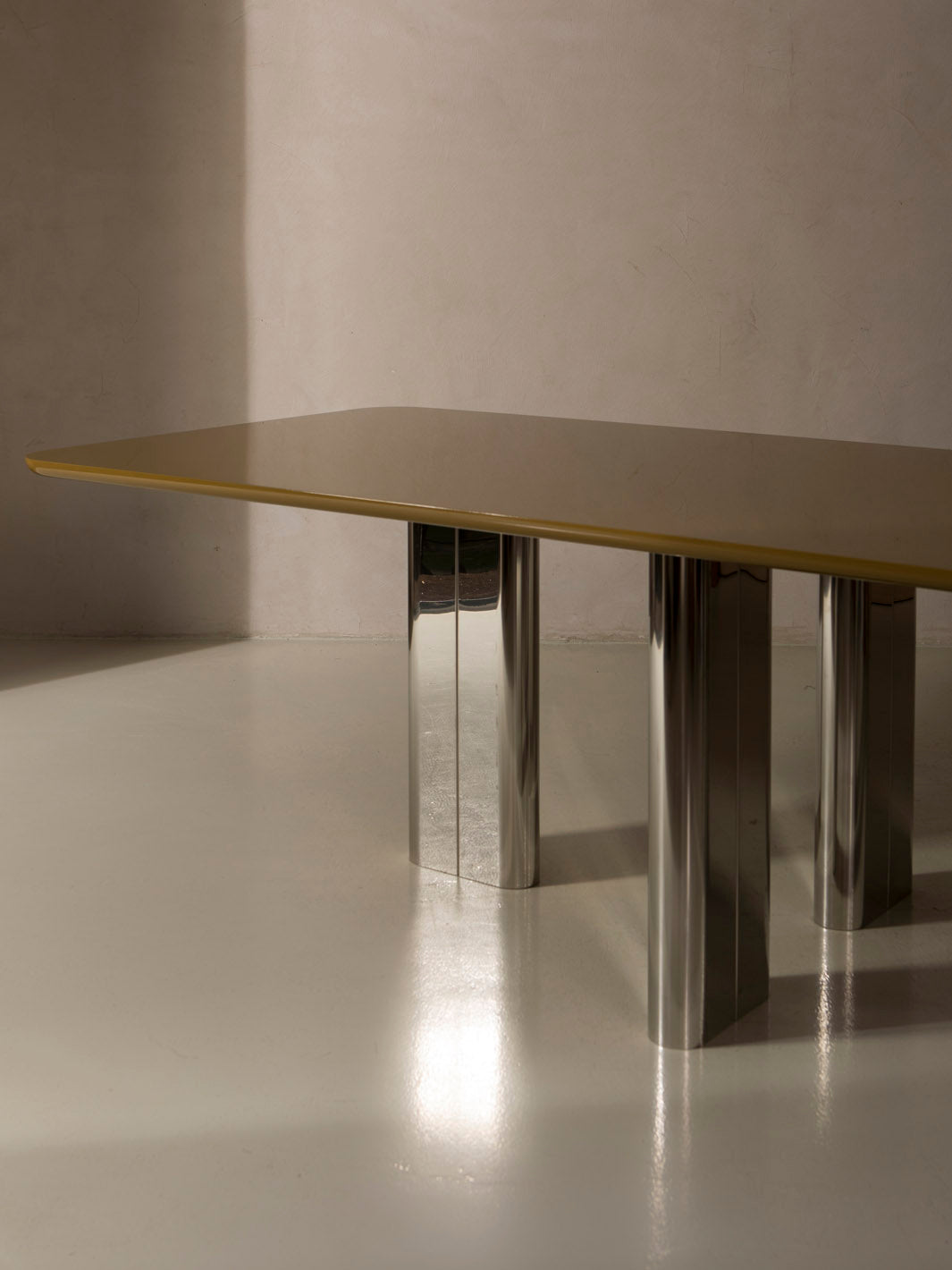 Mesa de comedor lacada en color ámbar con pata cromada