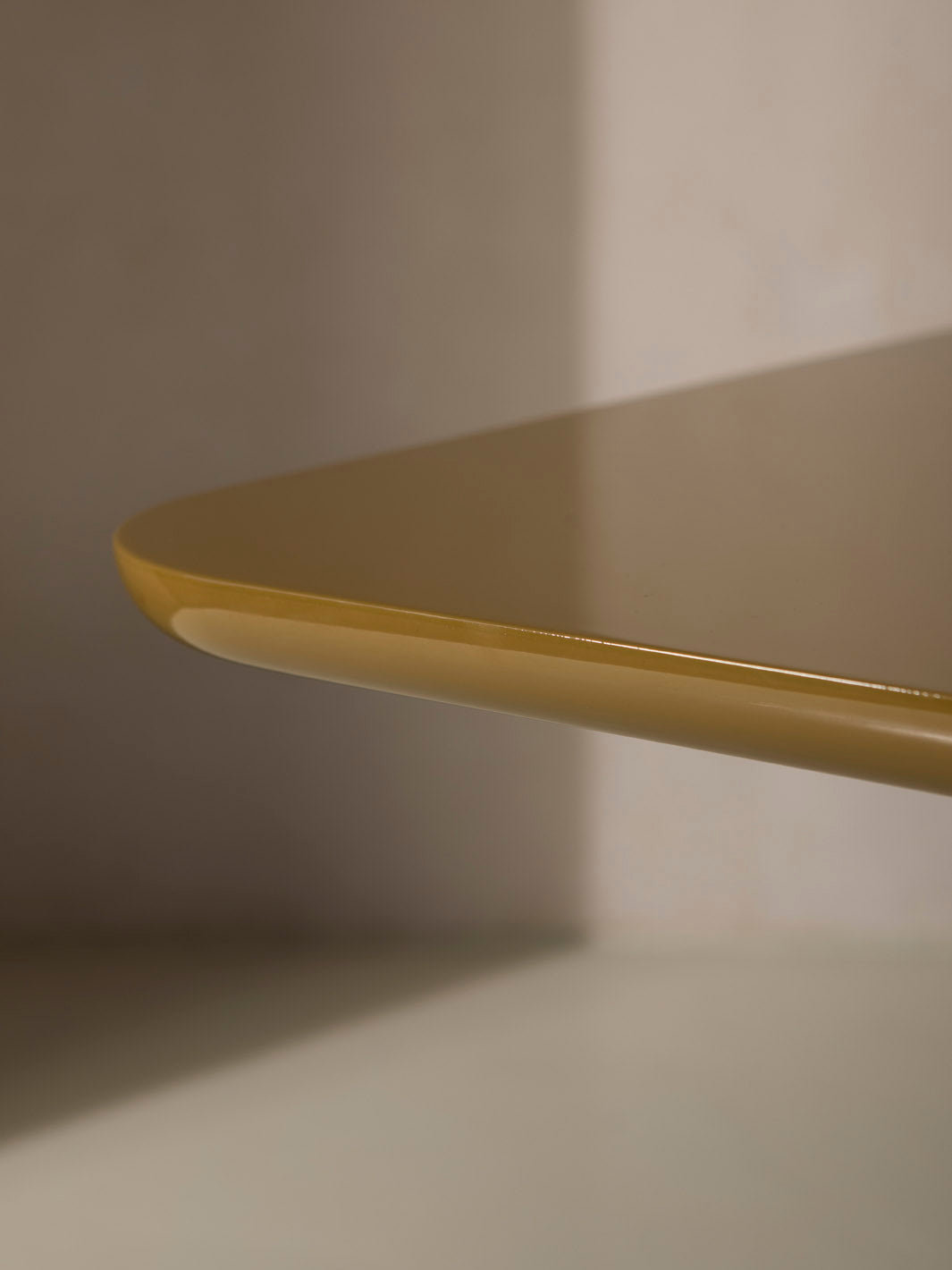 Mesa de comedor lacada en color ámbar con pata cromada