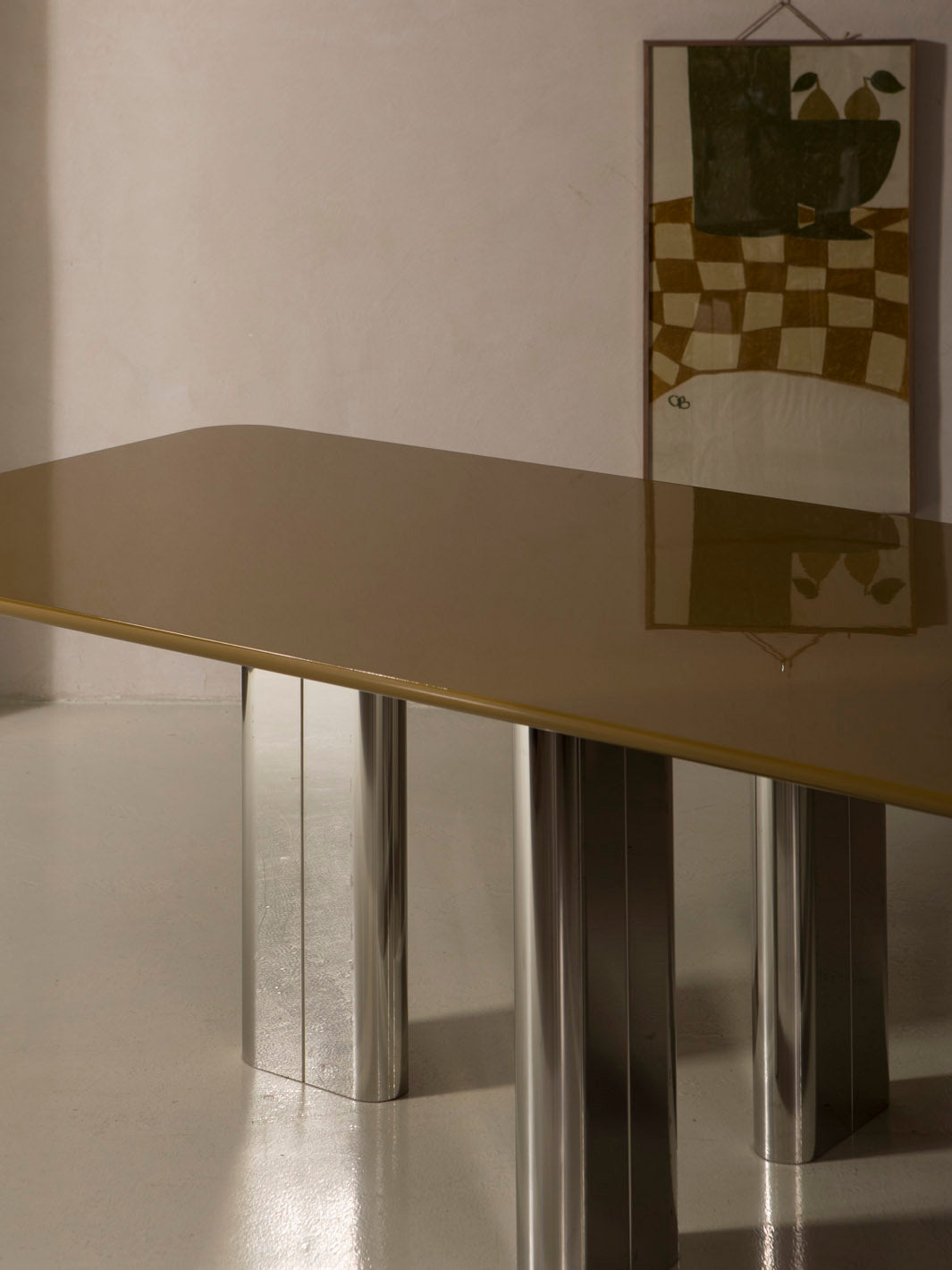 Mesa de comedor lacada en color ámbar con pata cromada