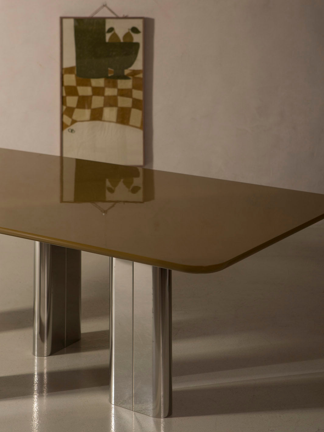 Mesa de comedor lacada en color ámbar con pata cromada