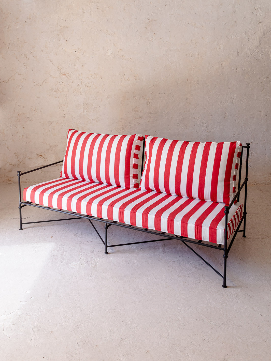 Red and white striped wrought iron sofa