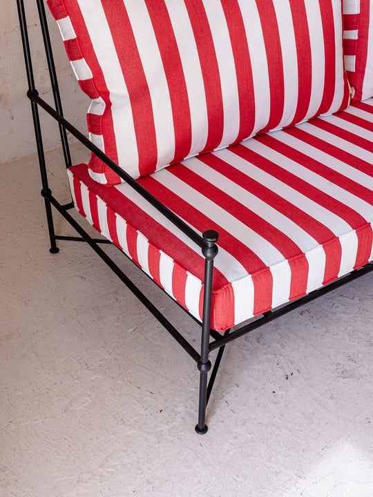 Red and white striped wrought iron sofa