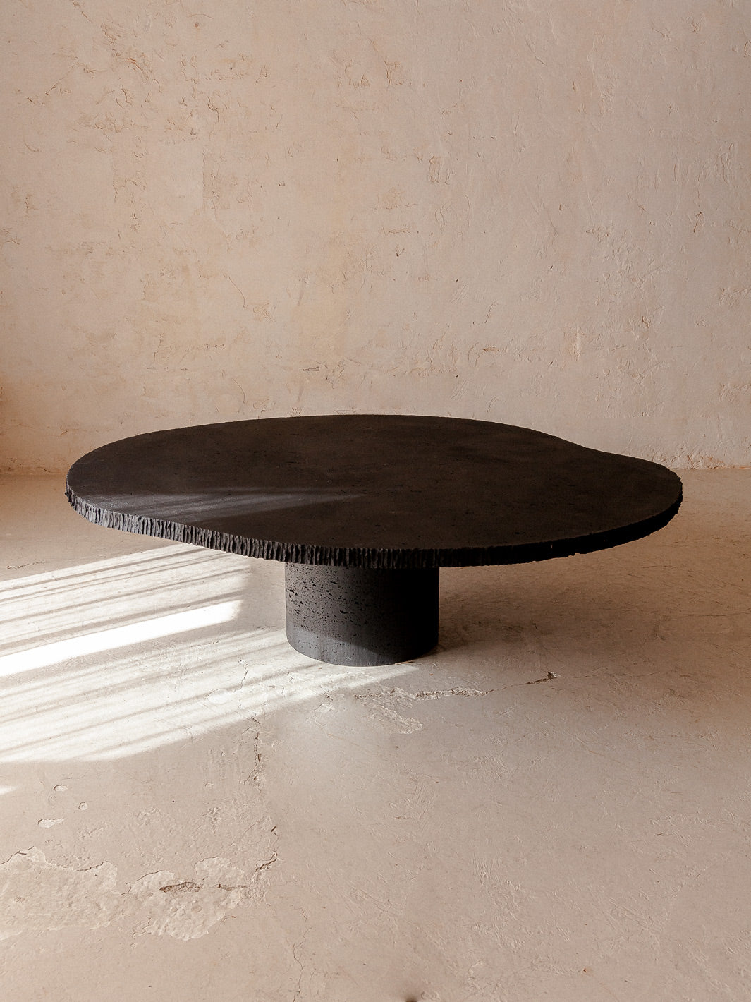 Organic black travertine marble table Ø130cm